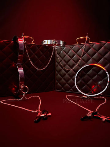 Metal collar with quilted strap, rings, and chain-linked nipple clamps