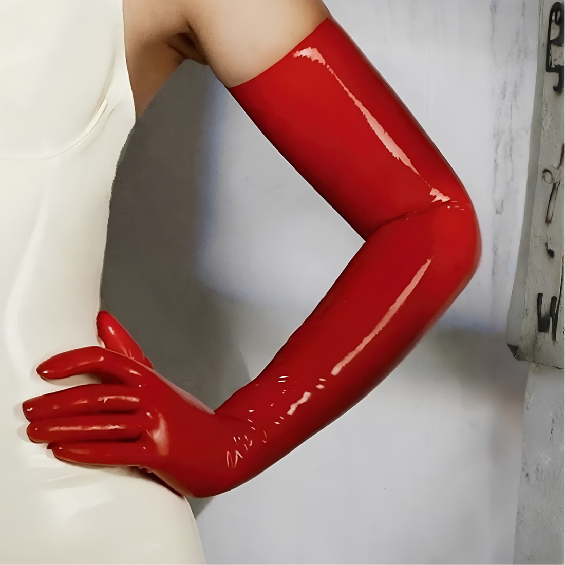 Red long latex gloves close-up with glossy surface and tapered cuffs.