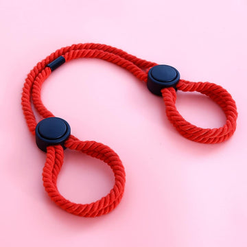 Red adjustable rope handcuff with black round end caps, braided loops